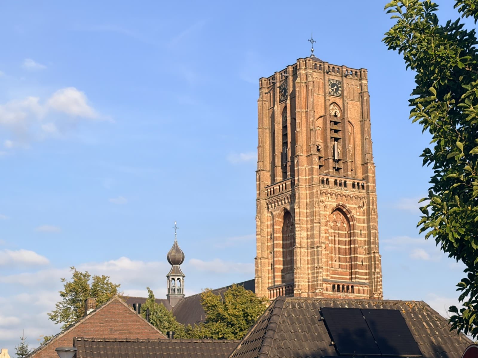 De toren van de basiliek boven de daken van Oirschot