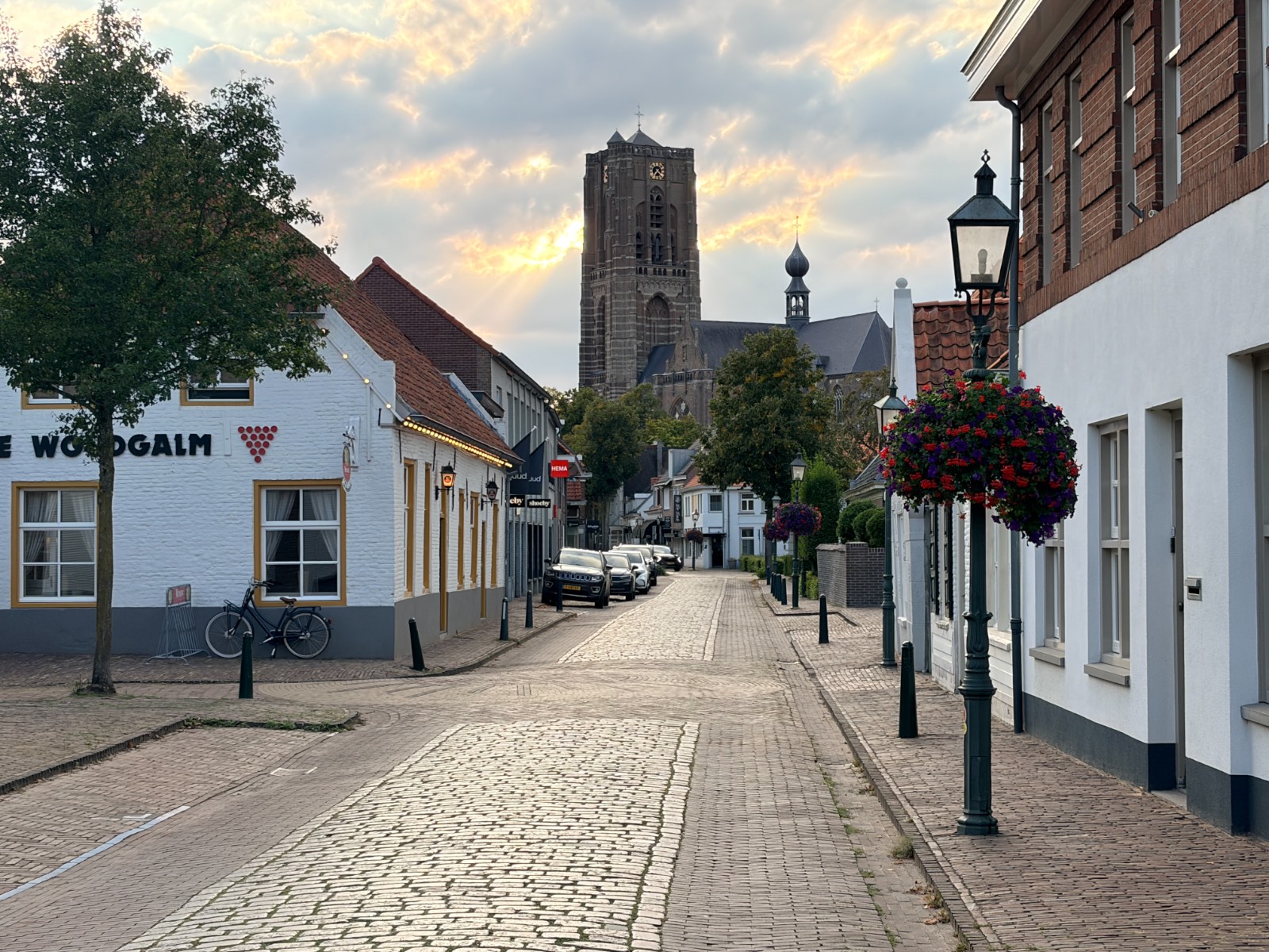 De Rijkesluisstraat in Oirschot met de toren van de Sint-Petrusbasiliek in het avondlicht